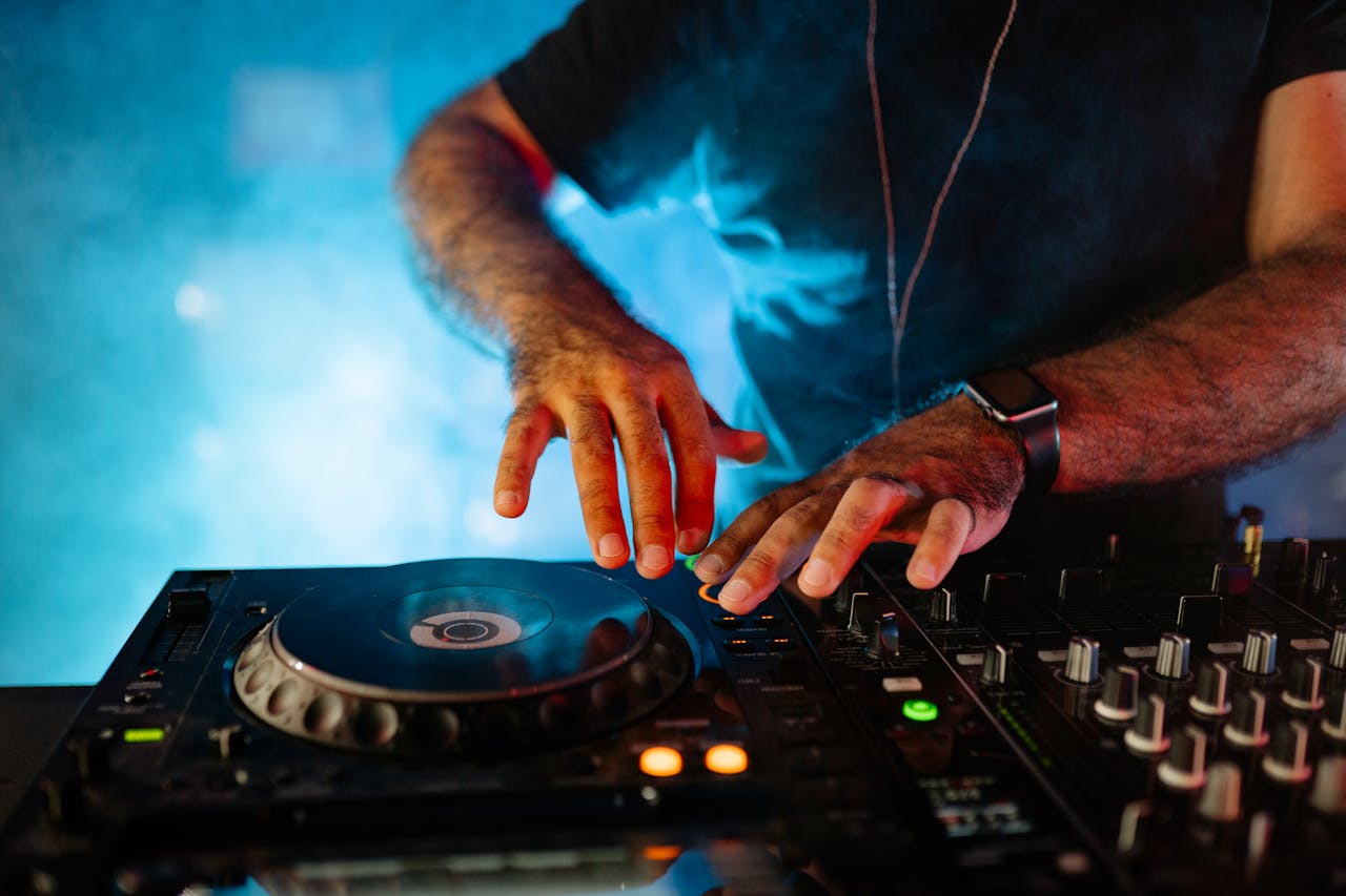 A DJ skillfully mixes music on a professional mixer in a vibrant nightclub setting.